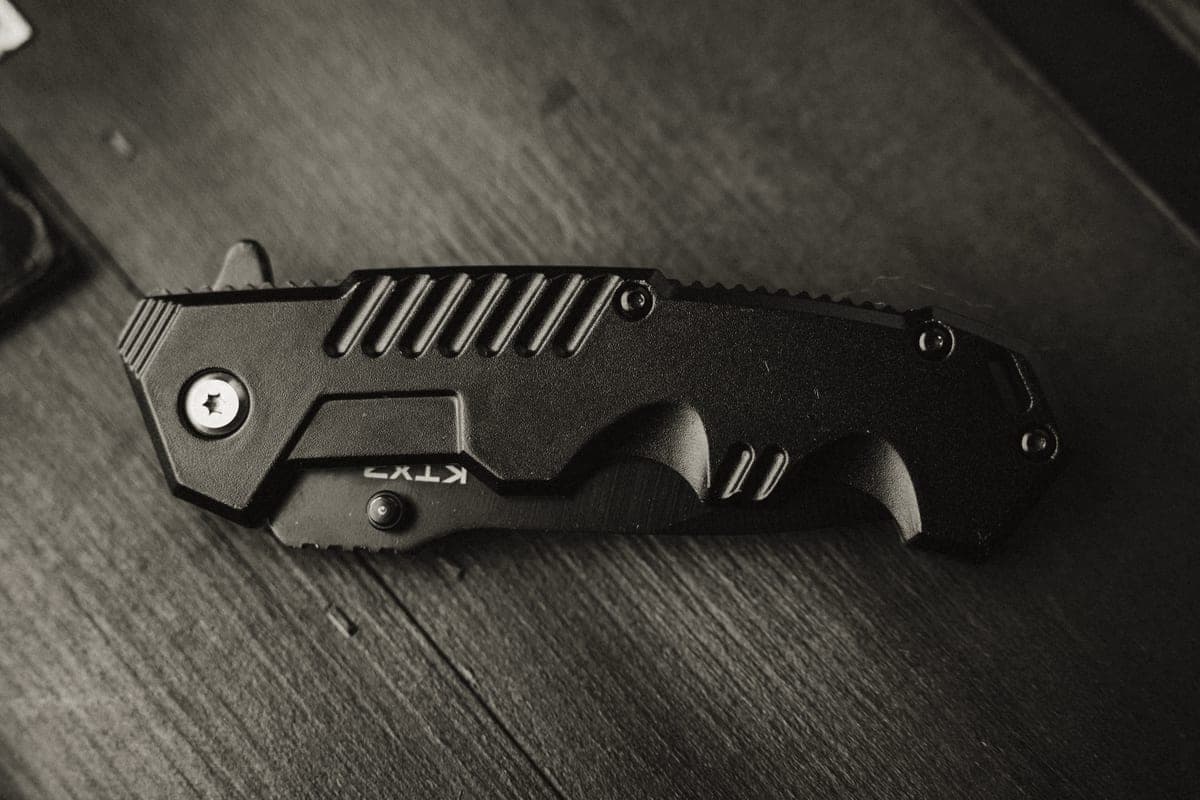 A folding pocket knife resting on a weathered wooden surface